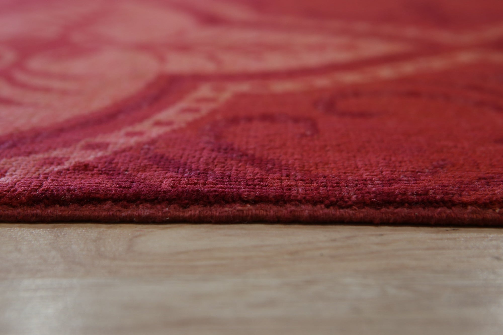 Penelope Maya Red Hand Knotted Afghan Wool Rug, a vibrant red wool rug with intricate hand-knotted patterns, filling a comfortably furnished living room.