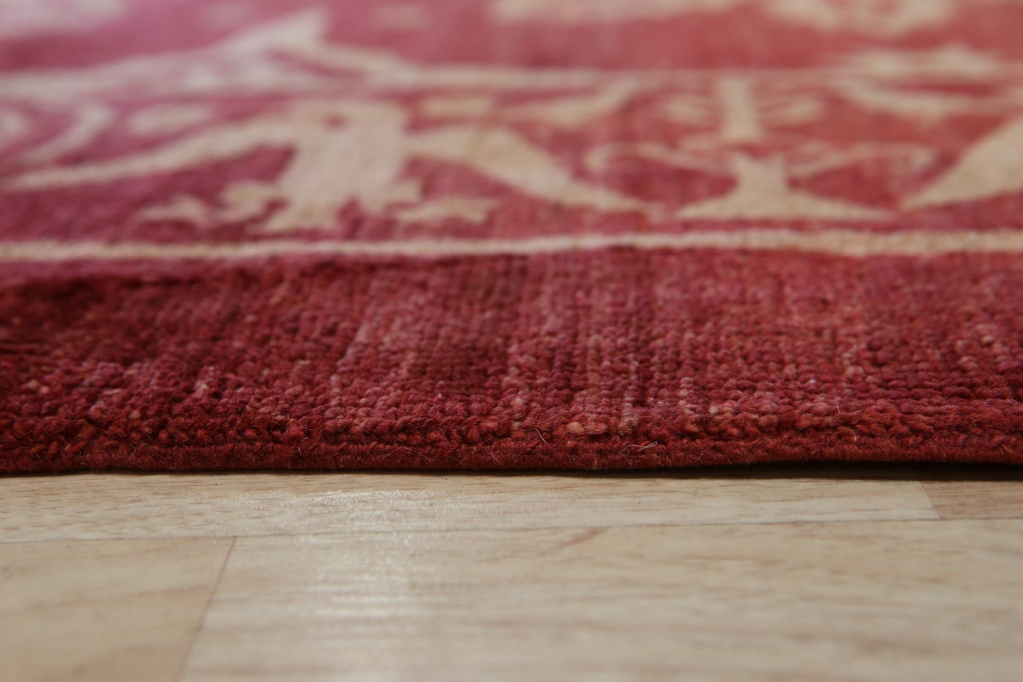 Majestic Artisan Red Hand Knotted Afghan Wool Rug, a richly patterned red wool rug with intricate geometric designs, seen in a staged living room setting adding warmth and texture to the space.
