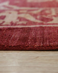 Majestic Artisan Red Hand Knotted Afghan Wool Rug, a richly patterned red wool rug with intricate geometric designs, seen in a staged living room setting adding warmth and texture to the space.