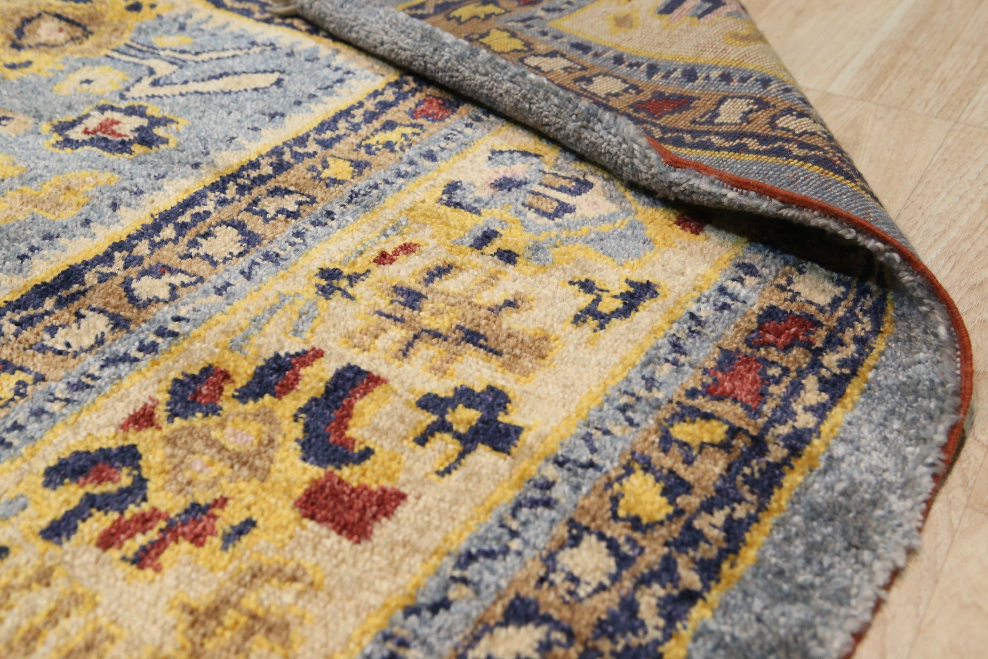 Handcrafted Oushak Blue Hand Knotted Rug, showcasing intricate floral patterns in calming blues and creams, lending an air of timeless elegance to a warmly lit living space.