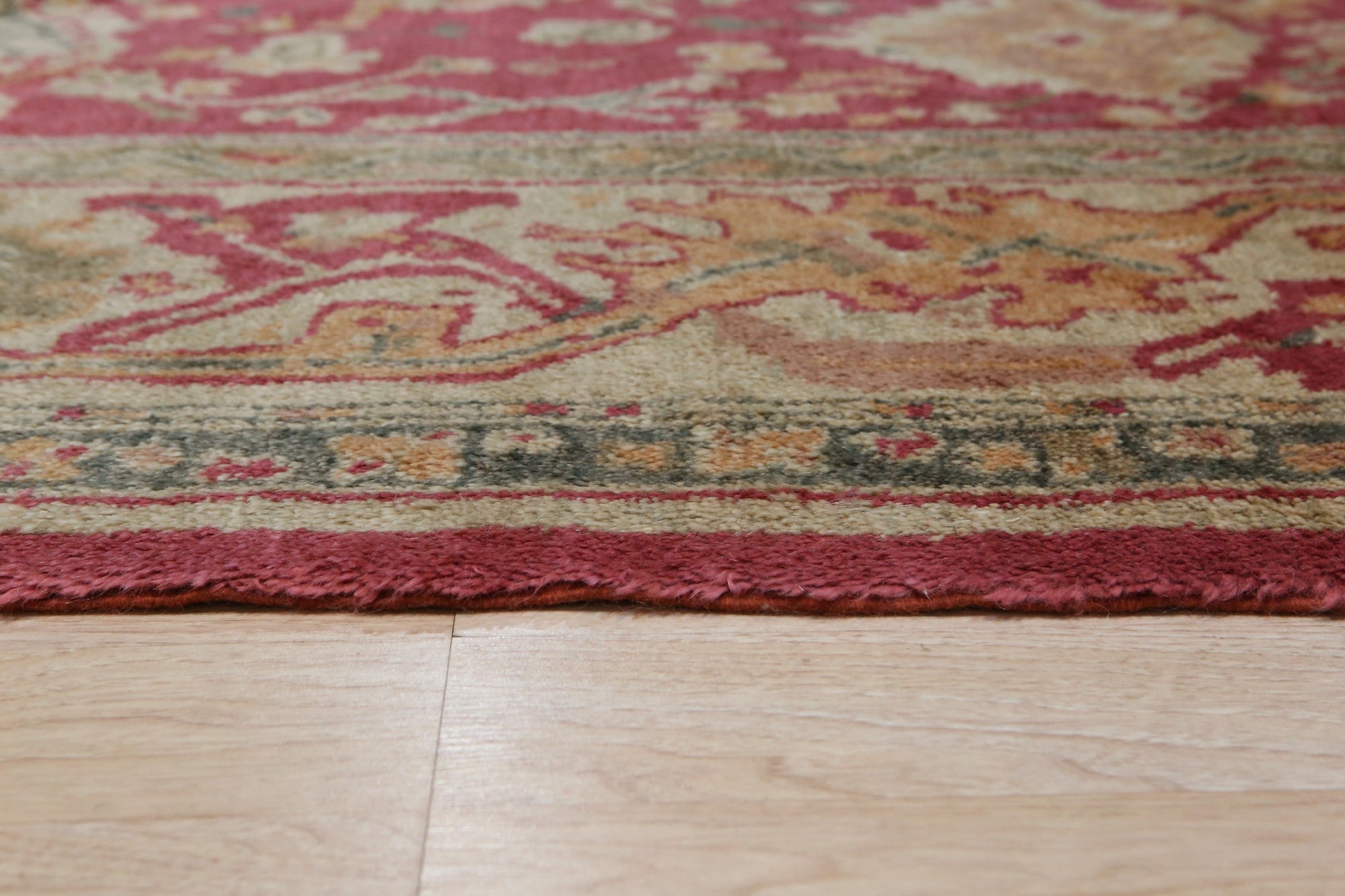 Opulent Oushak Red Hand Knotted Rug, saturated in rich reds and warm neutrals, hand-knotted wool with intricate floral motifs, adding classic elegance to a softly lit room.