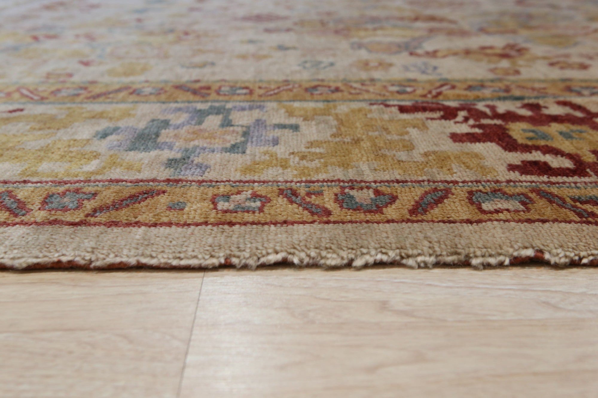 Jade Oushak Beige Hand Knotted Rug, a plush beige rug with intricate floral motifs and a soft, inviting texture, displayed as part of a larger room setting.