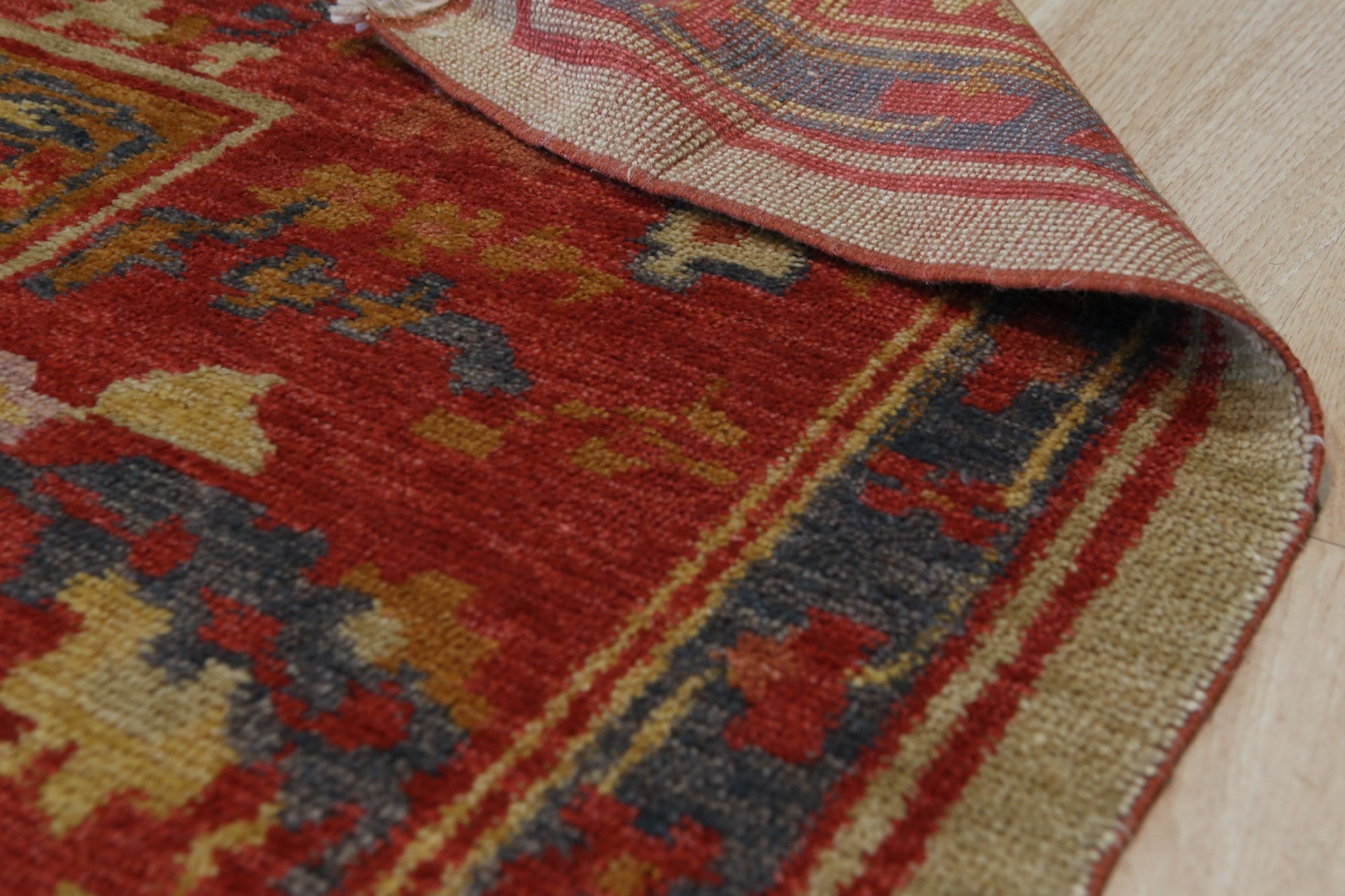 Selene Oushak Red Hand Knotted Rug, its intricate floral patterns and rich red hues warming a softly lit interior.