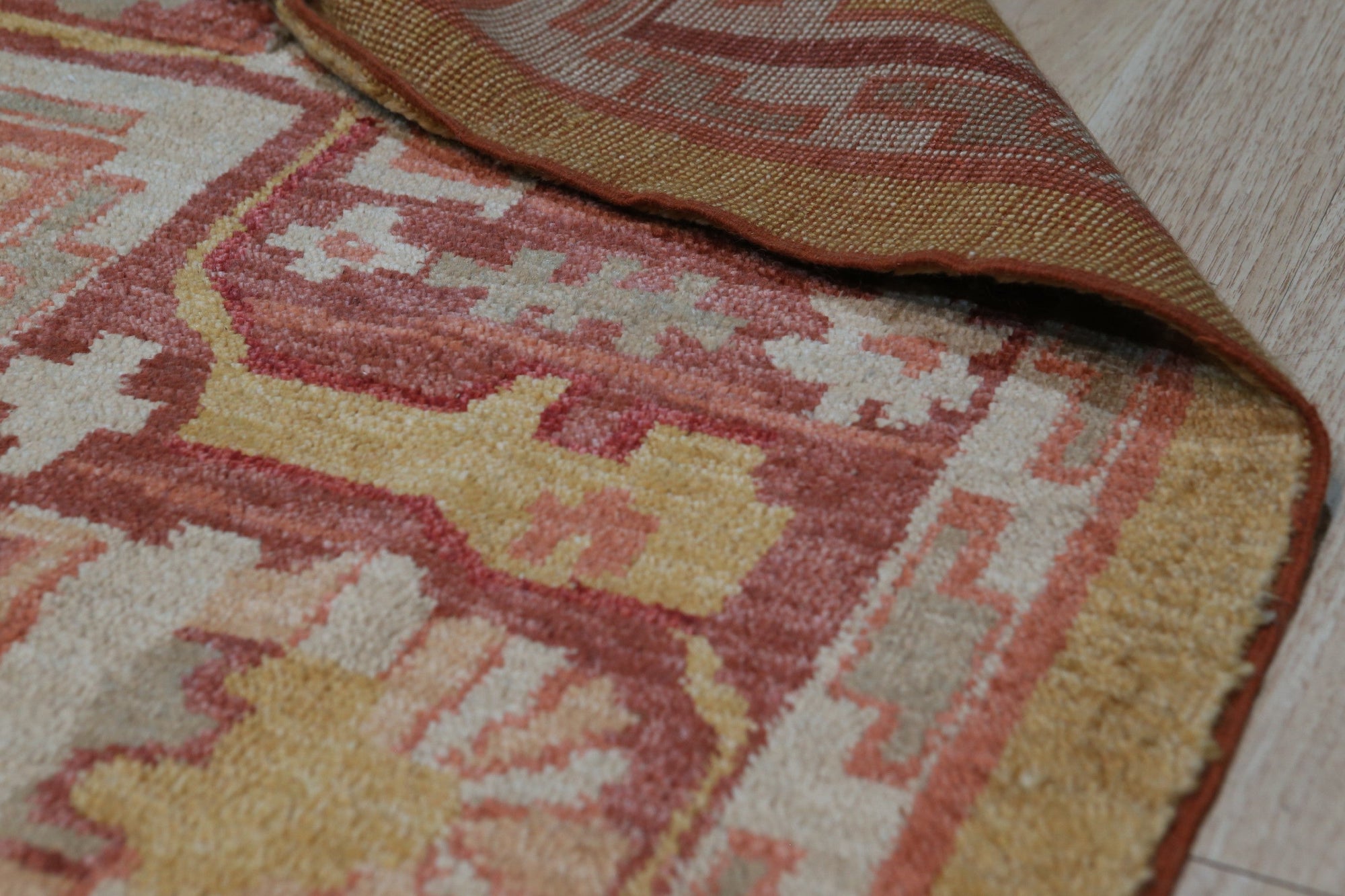 Beautiful Oushak Gold Hand Knotted Rug, its warm gold hues and intricate hand-knotted details radiating from the center of a room setting, suggesting luxurious comfort underfoot.