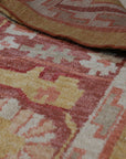 Beautiful Oushak Gold Hand Knotted Rug, its warm gold hues and intricate hand-knotted details radiating from the center of a room setting, suggesting luxurious comfort underfoot.
