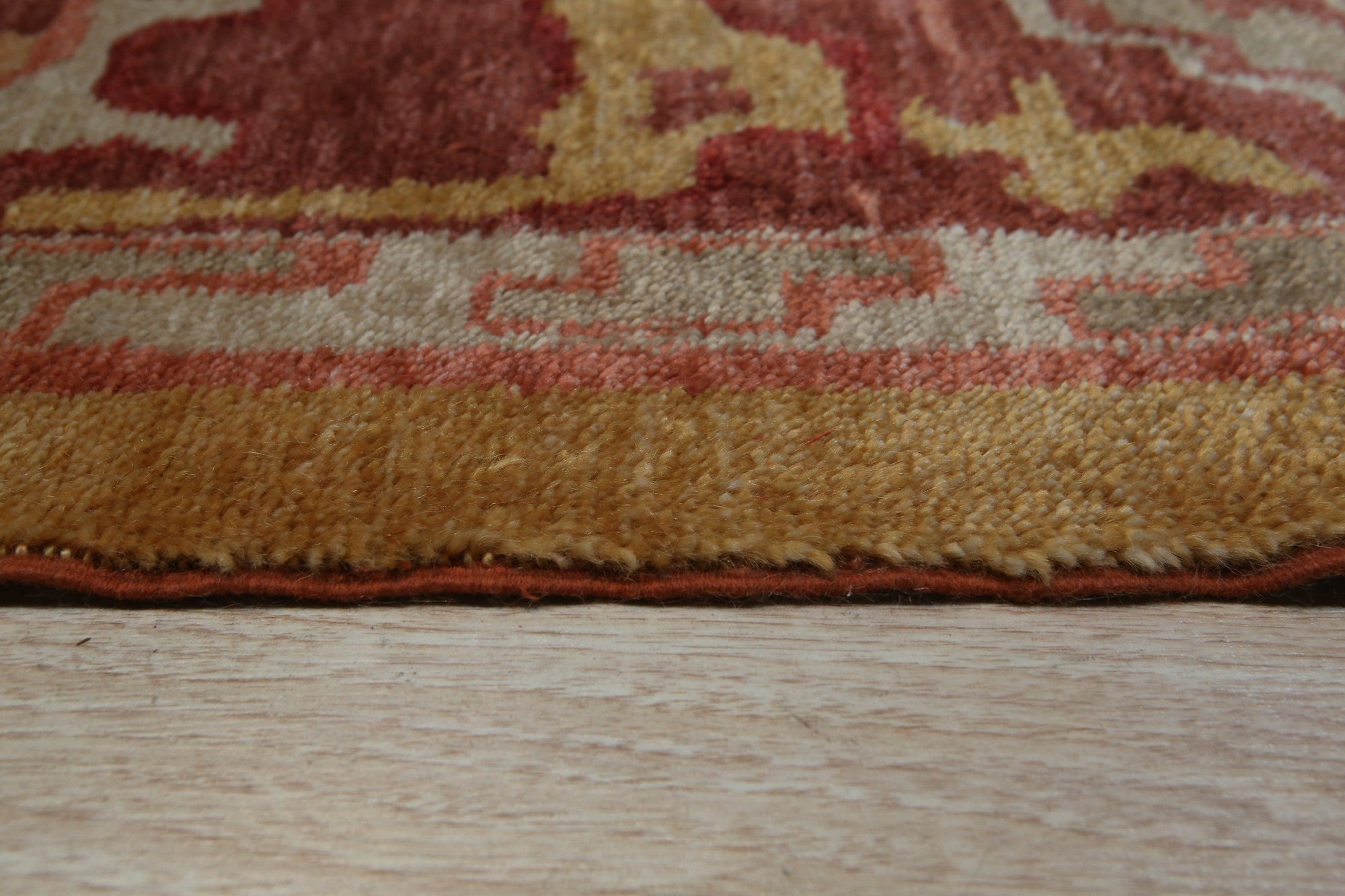 Beautiful Oushak Gold Hand Knotted Rug, its golden hues and hand-knotted construction complement a sun-drenched living room with white walls and light wood floors, adding warmth and texture to the inviting space.