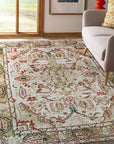 Delicate Oushak Beige Hand Knotted Rug, its soft beige tones and intricate floral design complementing a warmly lit living room. The hand-knotted texture and subtle variations in color evoke a sense of handcrafted luxury.
