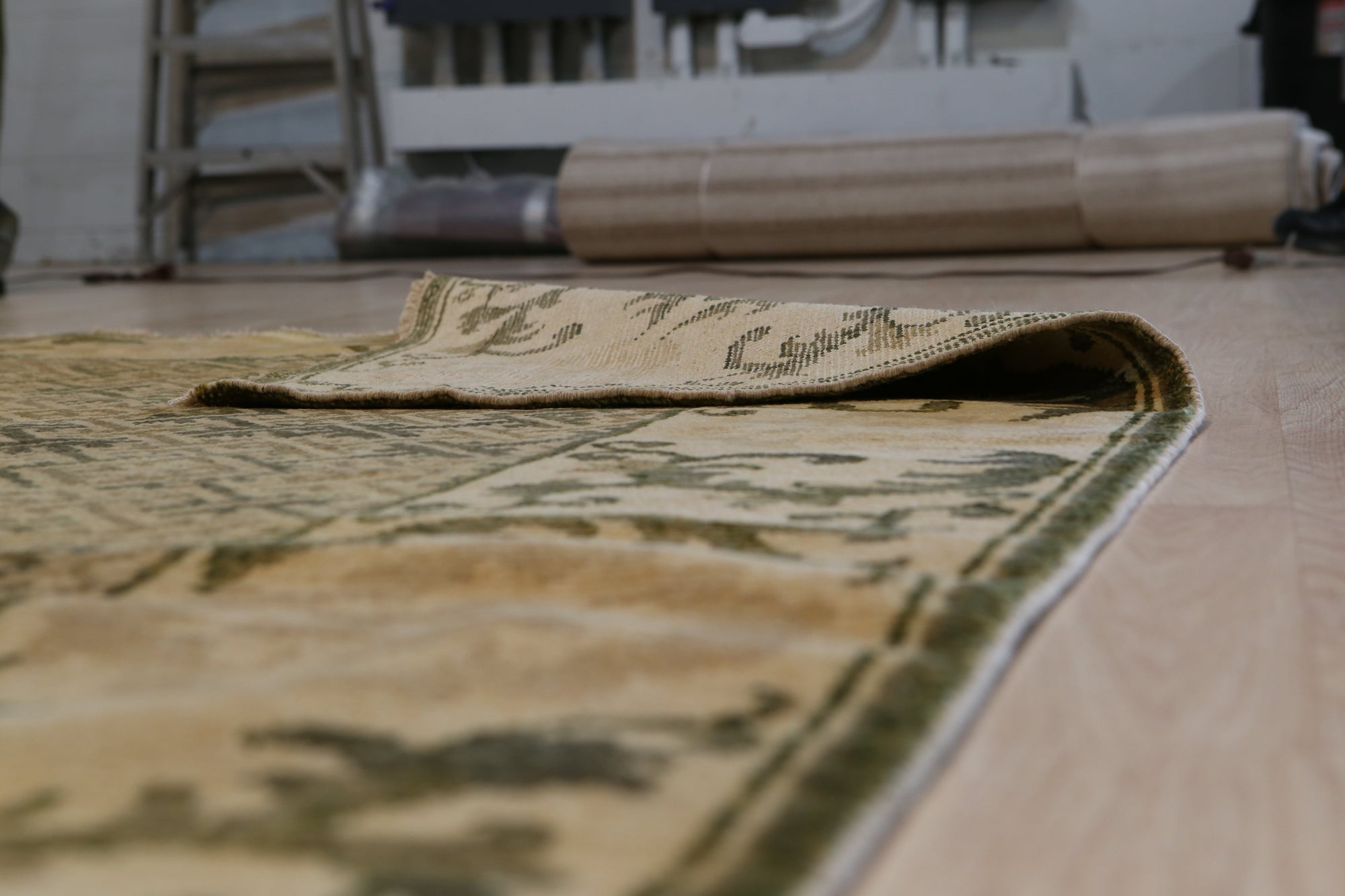 Classic Elena Green Hand Knotted Wool Rug, showcasing a lush green backdrop overlaid with an intricate, traditional floral pattern in muted tones, creating a timeless elegance under a soft, natural light.