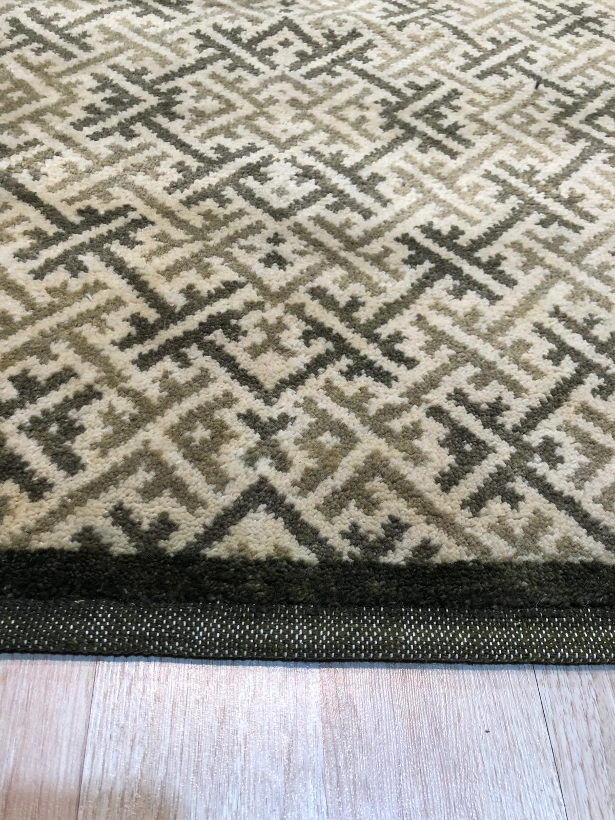 Classic Elena Green Hand Knotted Wool Rug, featuring a traditional, detailed pattern in shades of green, cream, and muted red, displayed in a brightly lit living room setting with neutral furniture.