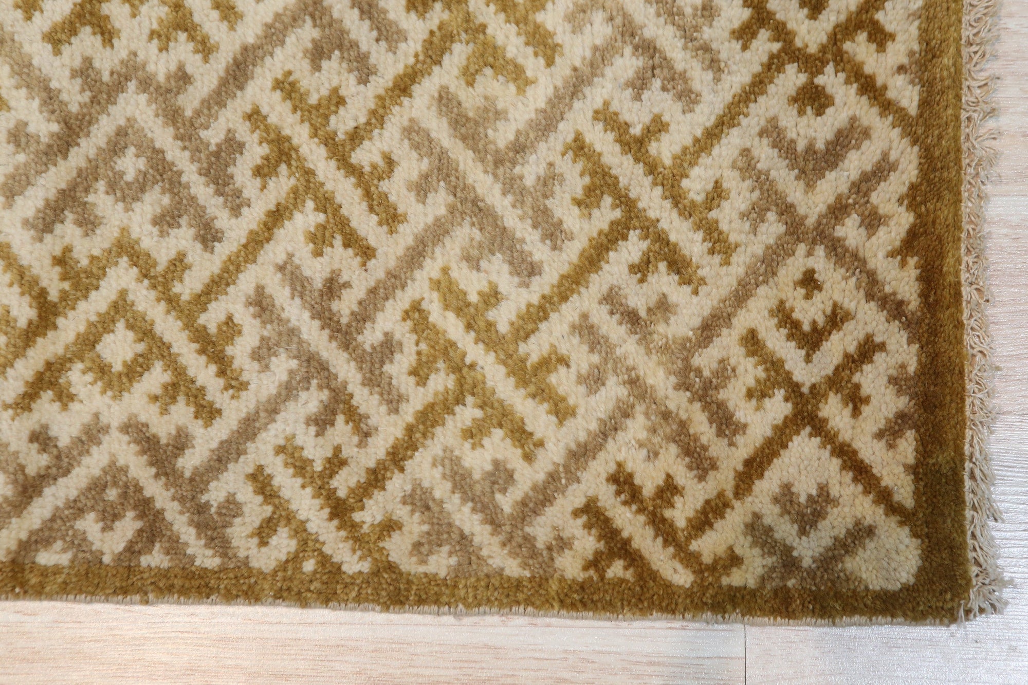Willow Opulent Gold Hand Knotted Wool Rug, its warm gold tones and intricate hand-knotted details adding a touch of luxurious texture to a sunlit living space with wooden floors.