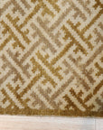 Willow Opulent Gold Hand Knotted Wool Rug, its warm gold tones and intricate hand-knotted details adding a touch of luxurious texture to a sunlit living space with wooden floors.