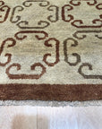 Louie Vibrant Brown Hand Knotted Wool Rug, showcasing warm, earthy tones and intricate hand-knotted details, softening a modern living room with hardwood floors and a minimalist aesthetic.