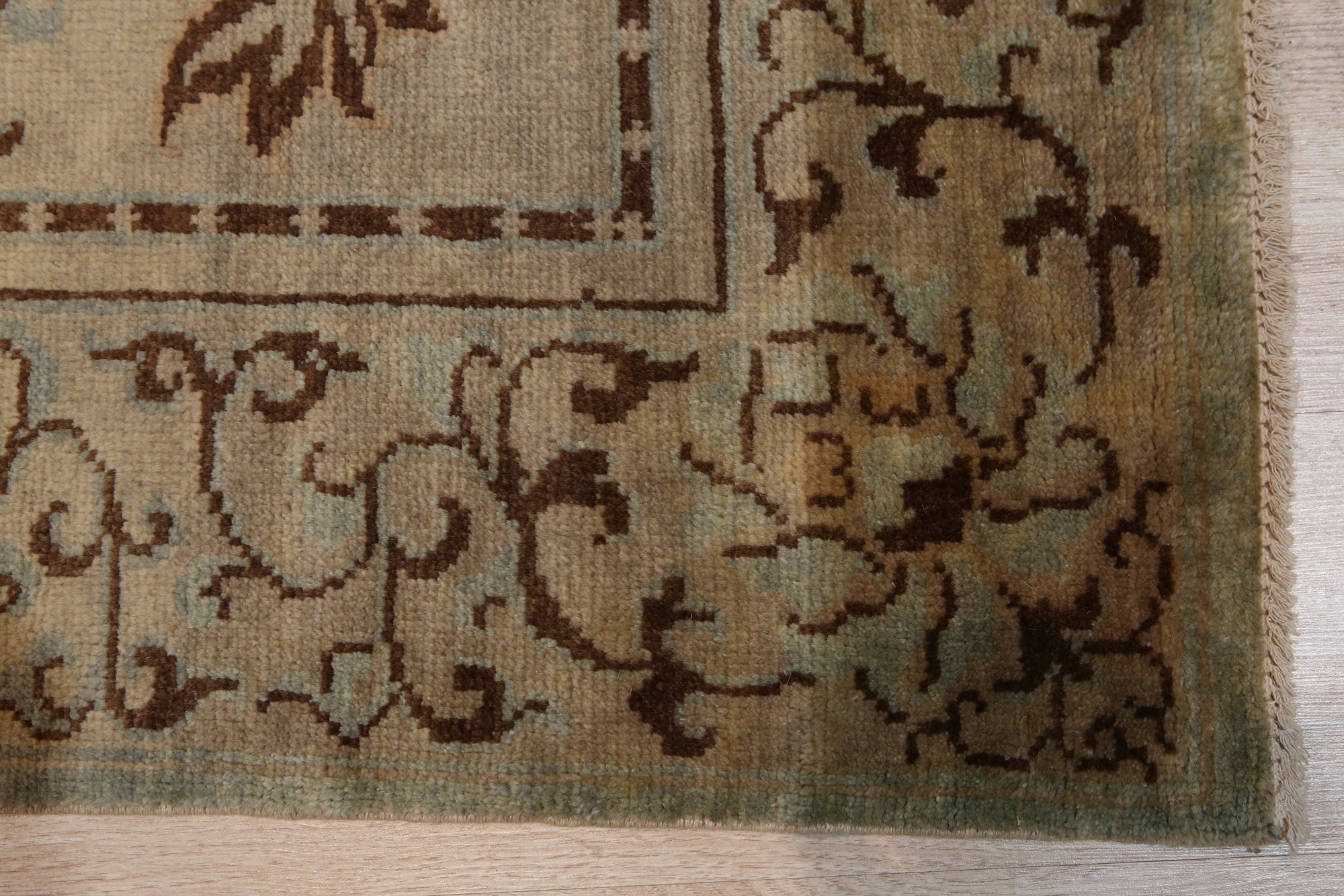 Elena Rustic Green Hand Knotted Wool Rug, showcasing its textured hand-knotted construction and earthy green tones, displayed in a warm, inviting living room setting.