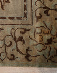 Elena Rustic Green Hand Knotted Wool Rug, showcasing its textured hand-knotted construction and earthy green tones, displayed in a warm, inviting living room setting.