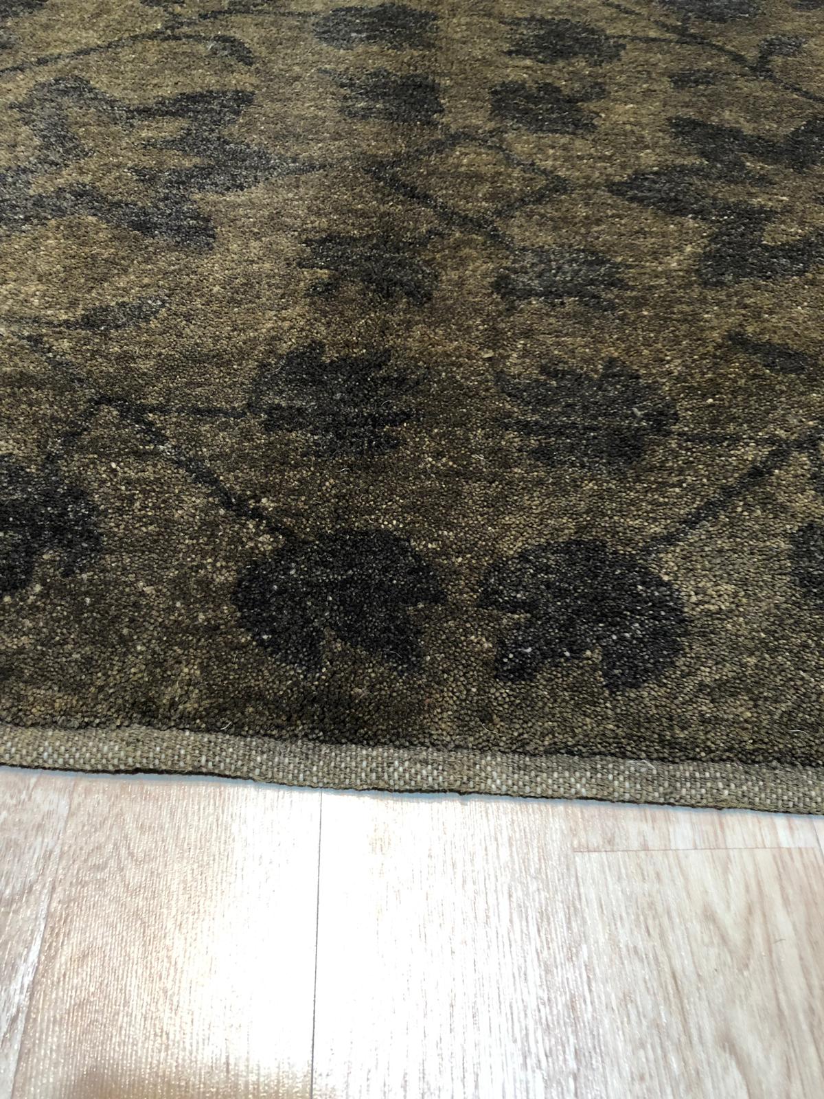 Unique Cozy Green Hand Knotted Wool Rug displayed in a bright, modern living room setting. The hand-knotted wool construction adds texture and warmth to the space, complemented by the vibrant green hues that create a cozy and inviting atmosphere.