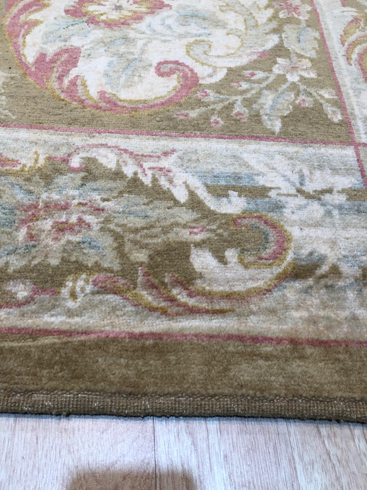 Elena Xena Beige Hand Knotted Wool Rug gracing a sunlit living room, its soft beige tones and intricate hand-knotted design complementing modern furniture.