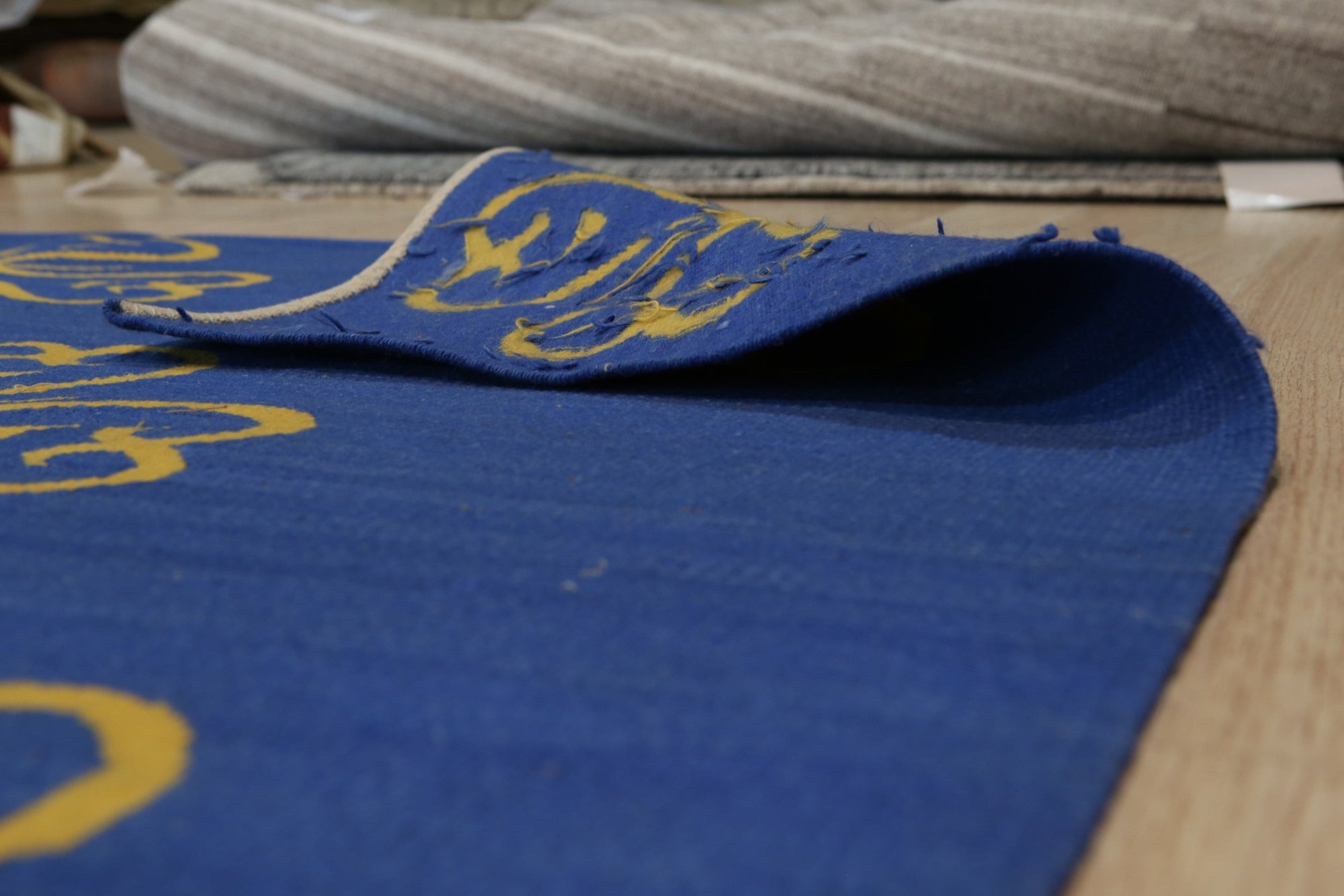 Elena Opulent Blue Flatweave Wool Rug, displaying a subtle, geometric pattern in varying shades of blue, lies flat on a light-toned floor, its textured wool visible under soft lighting.