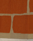 Kira Amara Orange Flatweave Wool Rug, vibrant orange and cream geometric pattern flatweave, lies gracefully on a light wooden floor, adding warmth and modern style to the room.