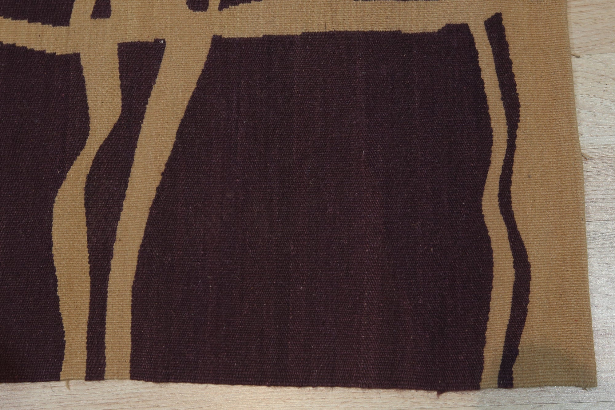 Stylish Iris Purple Flatweave Wool Rug, covering a portion of a light wood floor, its cool purple hues adding a touch of modern elegance to the room.