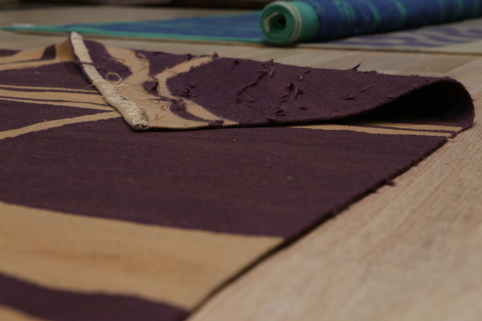 Stylish Iris Purple Flatweave Wool Rug, displaying a subtle geometric pattern in varying shades of purple and lavender, sits atop a light hardwood floor, creating a contemporary and inviting space.