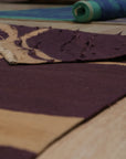 Stylish Iris Purple Flatweave Wool Rug, displaying a subtle geometric pattern in varying shades of purple and lavender, sits atop a light hardwood floor, creating a contemporary and inviting space.