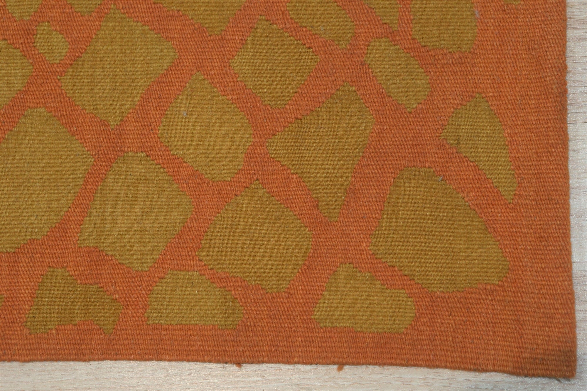 Artisan Handcrafted Rust Flatweave Wool Rug, showcasing a warm rust hue and subtle texture in a bright, modern living room setting.