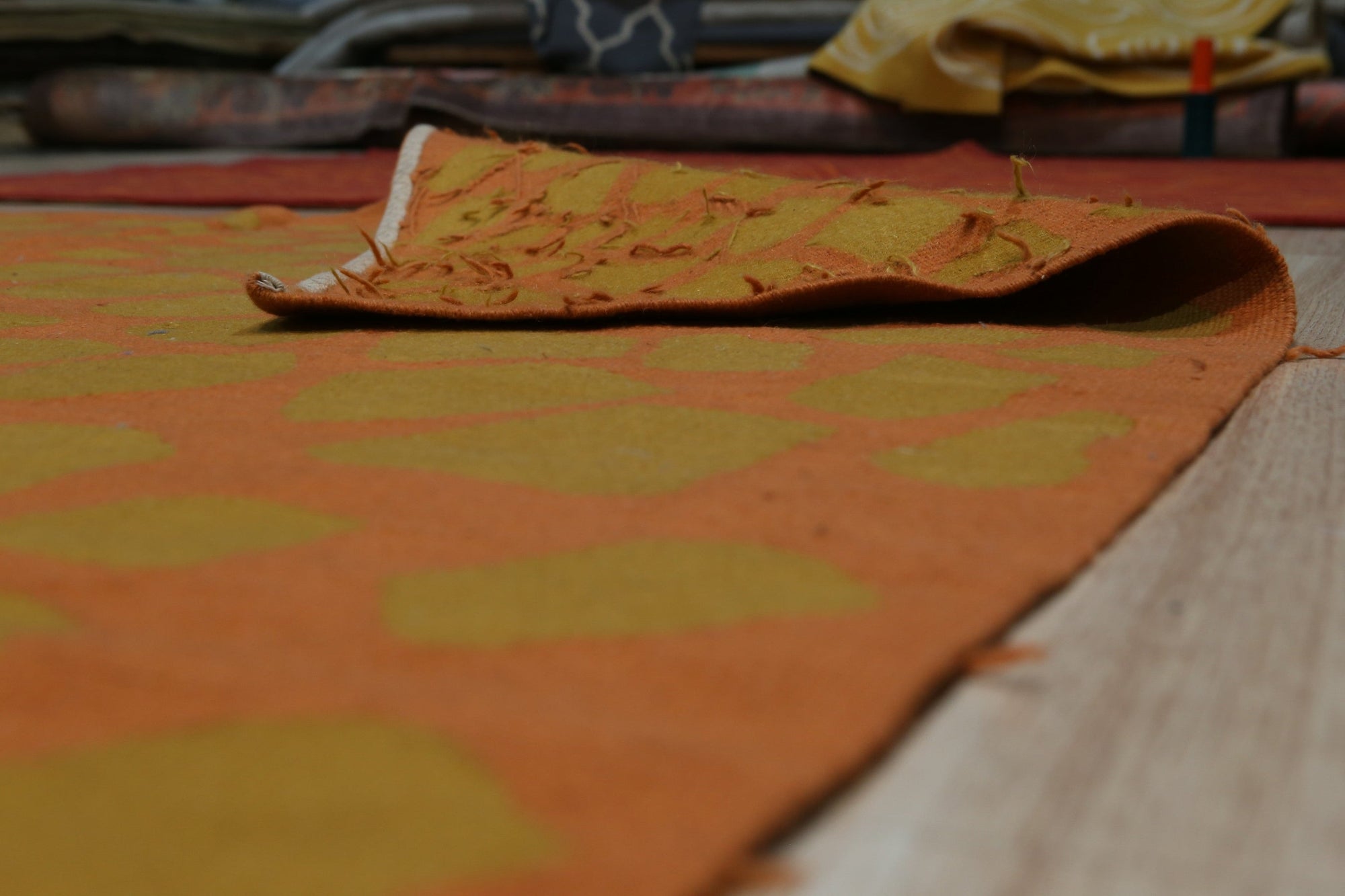 Artisan Handcrafted Rust Flatweave Wool Rug gracing a sun-drenched living space, its warm rust hues complementing the neutral sofa and natural wood accents; a testament to handcrafted wool construction.