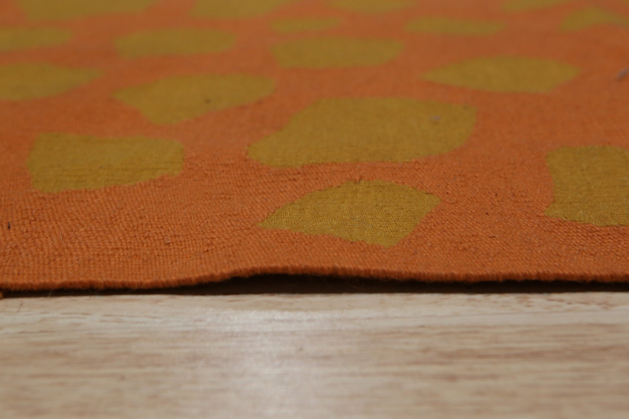 Artisan Handcrafted Rust Flatweave Wool Rug, its warm rust hues and flatweave texture grounding a softly lit living room.