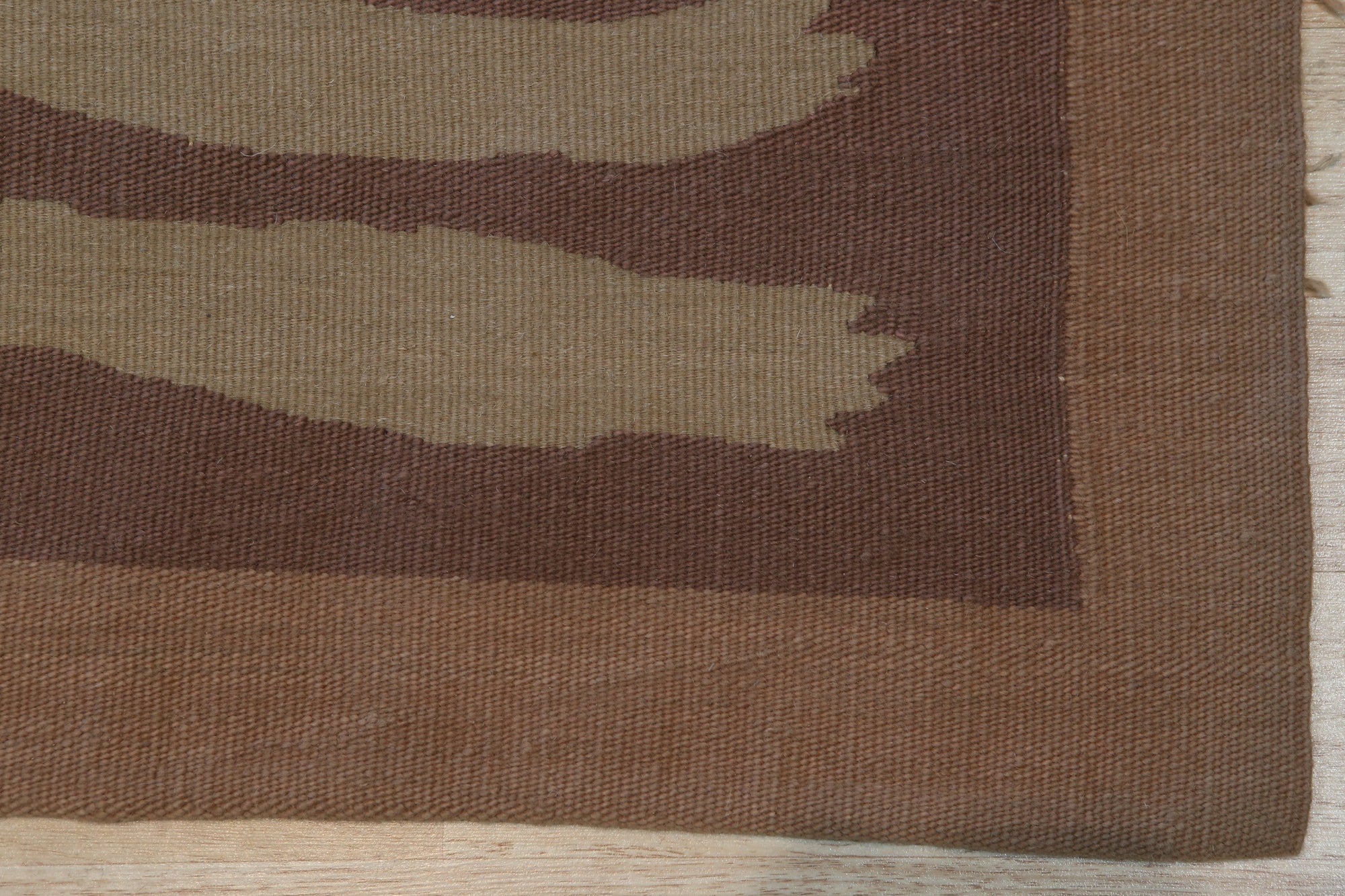 Freya Trendy Beige Flatweave Wool Rug, grounding a light-filled living room with its understated elegance, showcasing the subtle textural variations of the wool construction and calming beige tones.