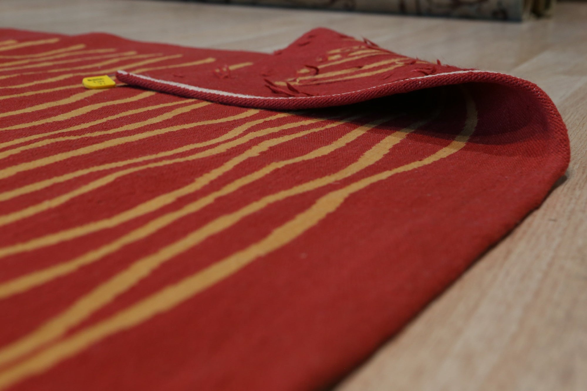 Trendy Sloane Red Flatweave Wool Rug, vibrant reds and subtle patterns create a warm texture in this flatweave wool rug, positioned on a wooden floor.