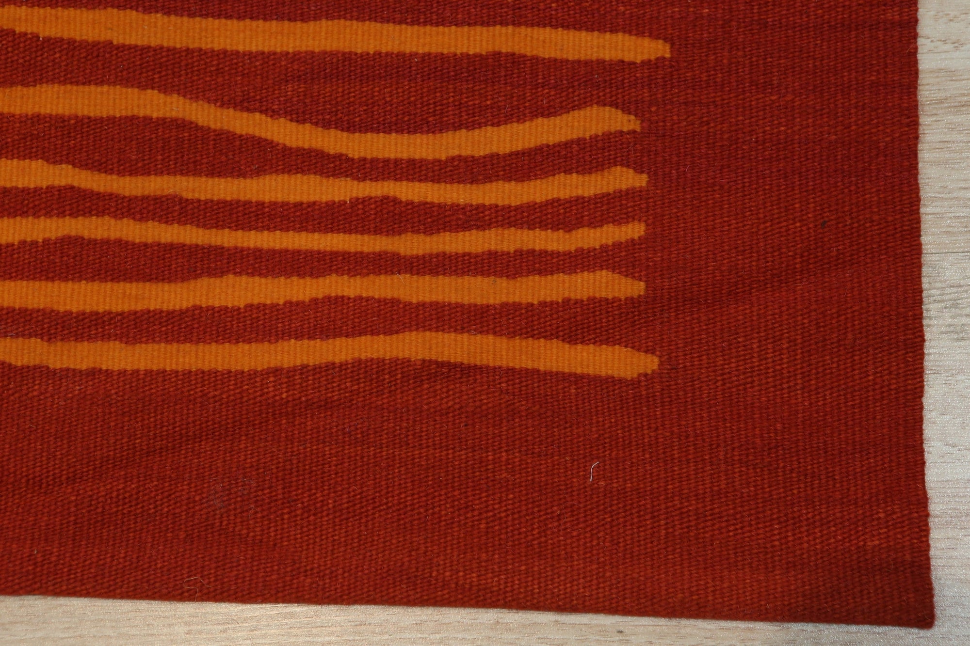 Timeless Stylish Red Flatweave Wool Rug, warm red tones and subtle pattern details adding texture to a bright living space, showcasing its flatweave construction.