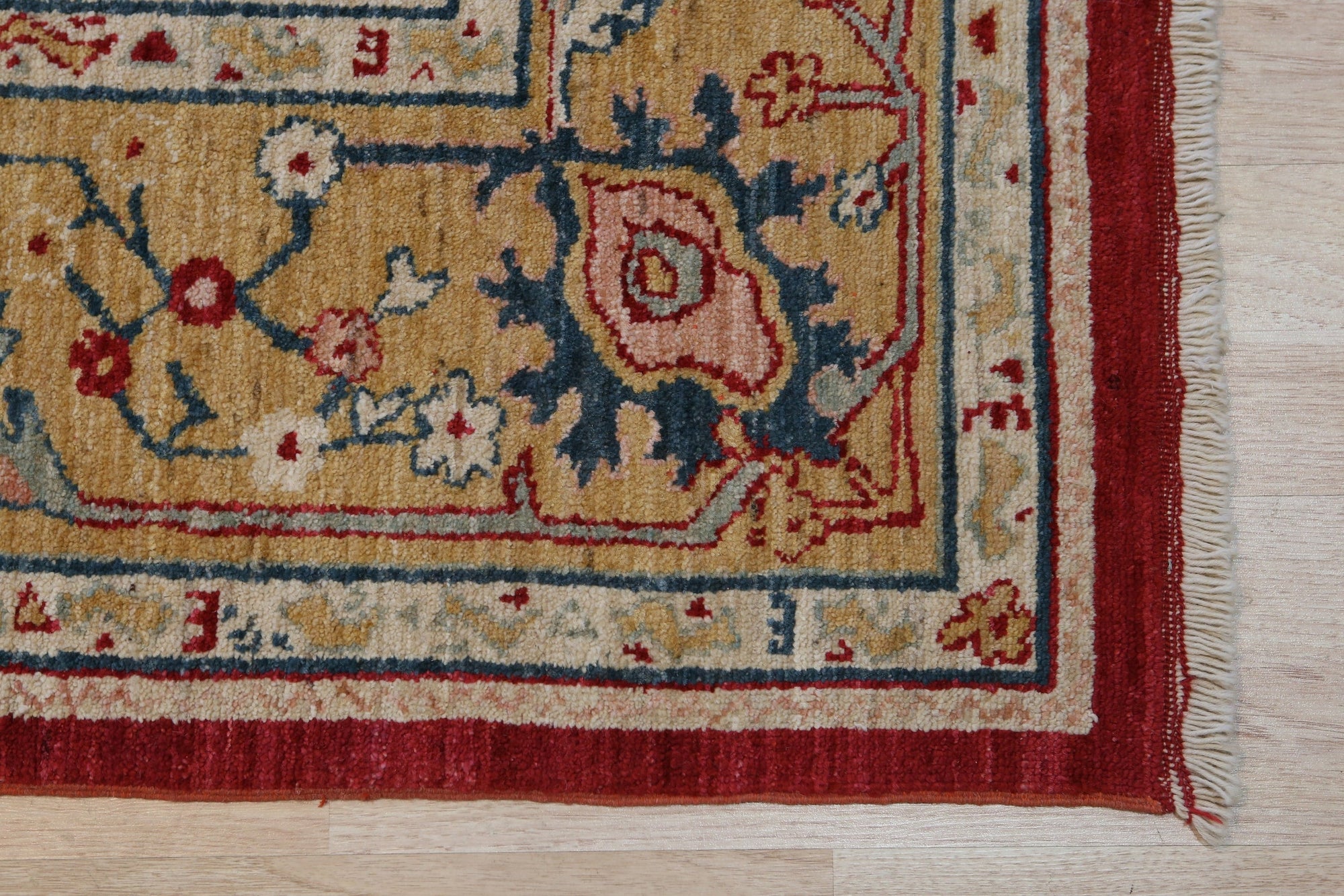 Enchanting Oushak Red Hand Knotted Wool Rug, a vibrant red wool rug featuring an intricate Oushak design, lies beautifully on a hardwood floor.