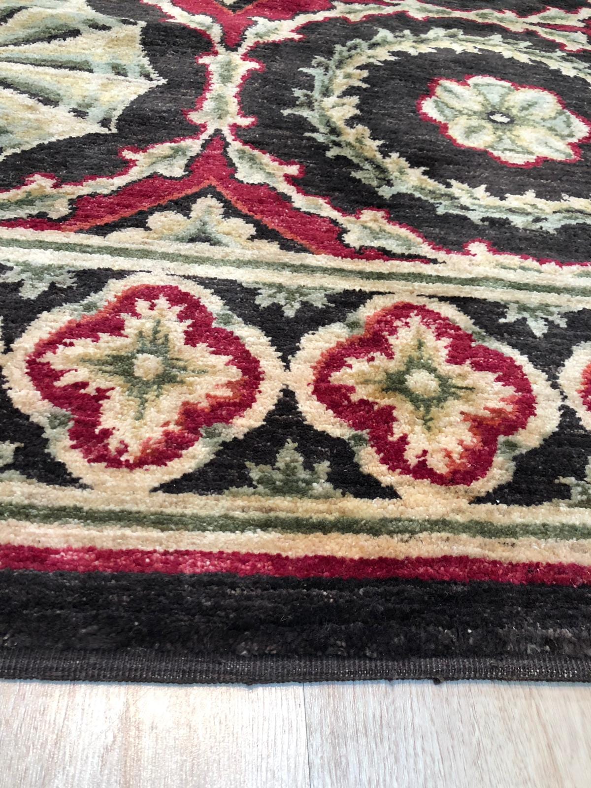 Giselle Violet Red Hand Knotted Wool Rug, a vibrant interplay of violet and red hues woven in wool, features a hand-knotted construction seen in a modern living space.