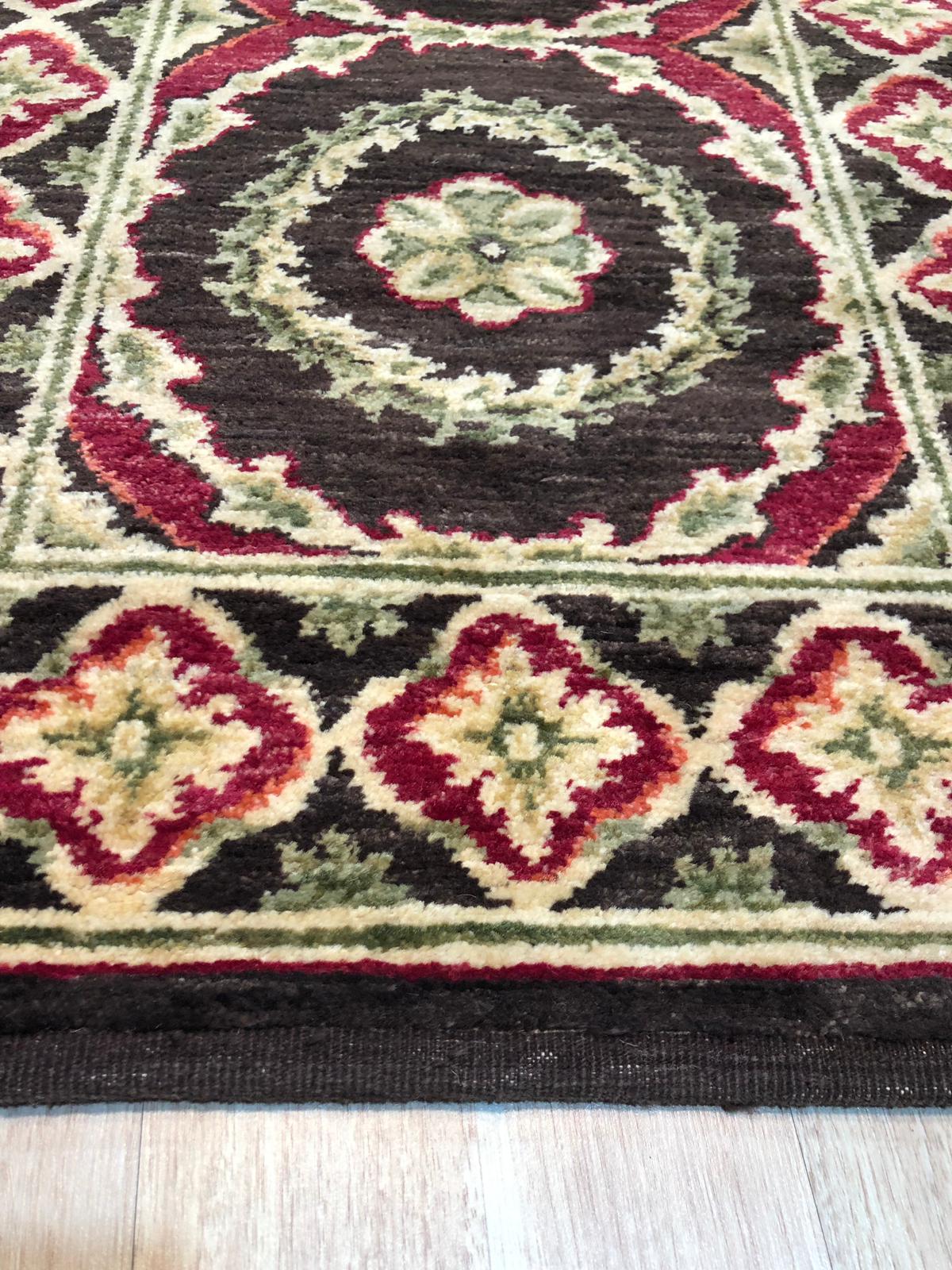 Giselle Violet Red Hand Knotted Wool Rug, showcasing a vibrant blend of violet and red hues in a hand-knotted wool construction, seen in a well-lit room setting.
