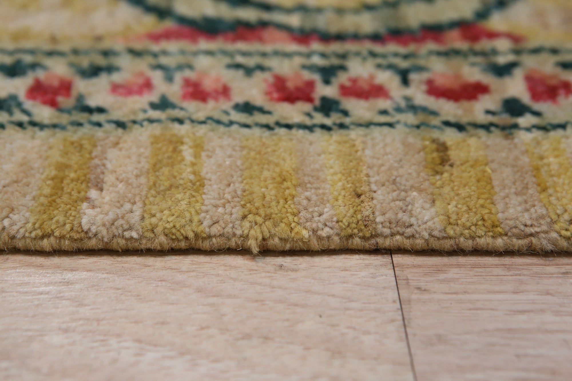 Iris Cozy Beige Hand Knotted Wool Rug, seen in a bright living room, offers a touch of warmth with its subtle beige hues and hand-knotted texture.