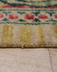 Iris Cozy Beige Hand Knotted Wool Rug, seen in a bright living room, offers a touch of warmth with its subtle beige hues and hand-knotted texture.