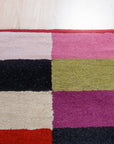 Captivating Amara Multicolored Hand Tufted Wool Rug, showcasing a vibrant blend of colors and textures in a living room setting.