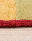 Captivating Amara Multicolored Hand Tufted Wool Rug, vibrant hues dance across a plush wool field, offering a modern bohemian accent to a softly lit living space.