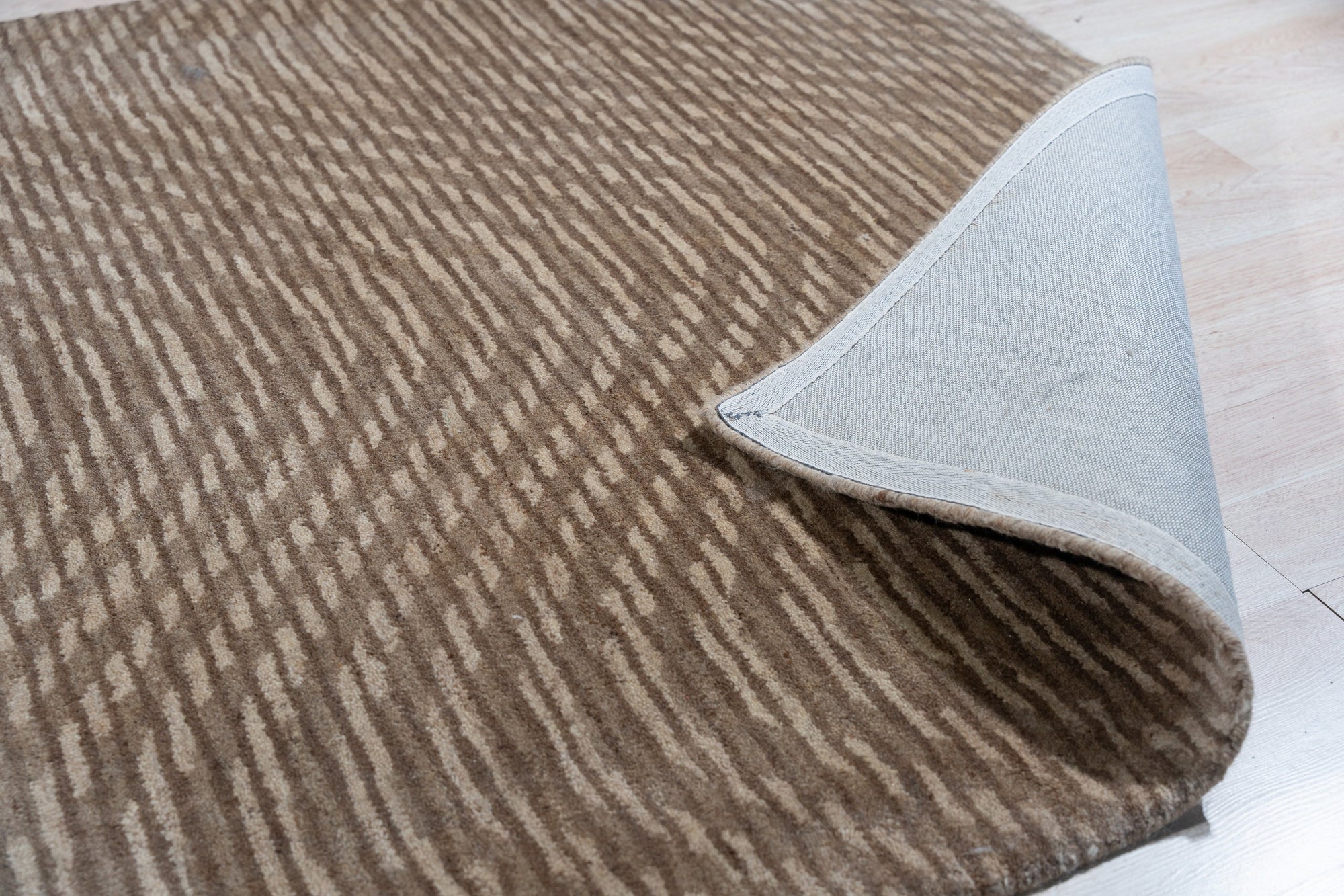 Sloane Freya Brown Hand Tufted Wool Rug, showcasing a textured, neutral palette in a cozy living room setting, highlighting its warm brown tones and handcrafted wool construction.