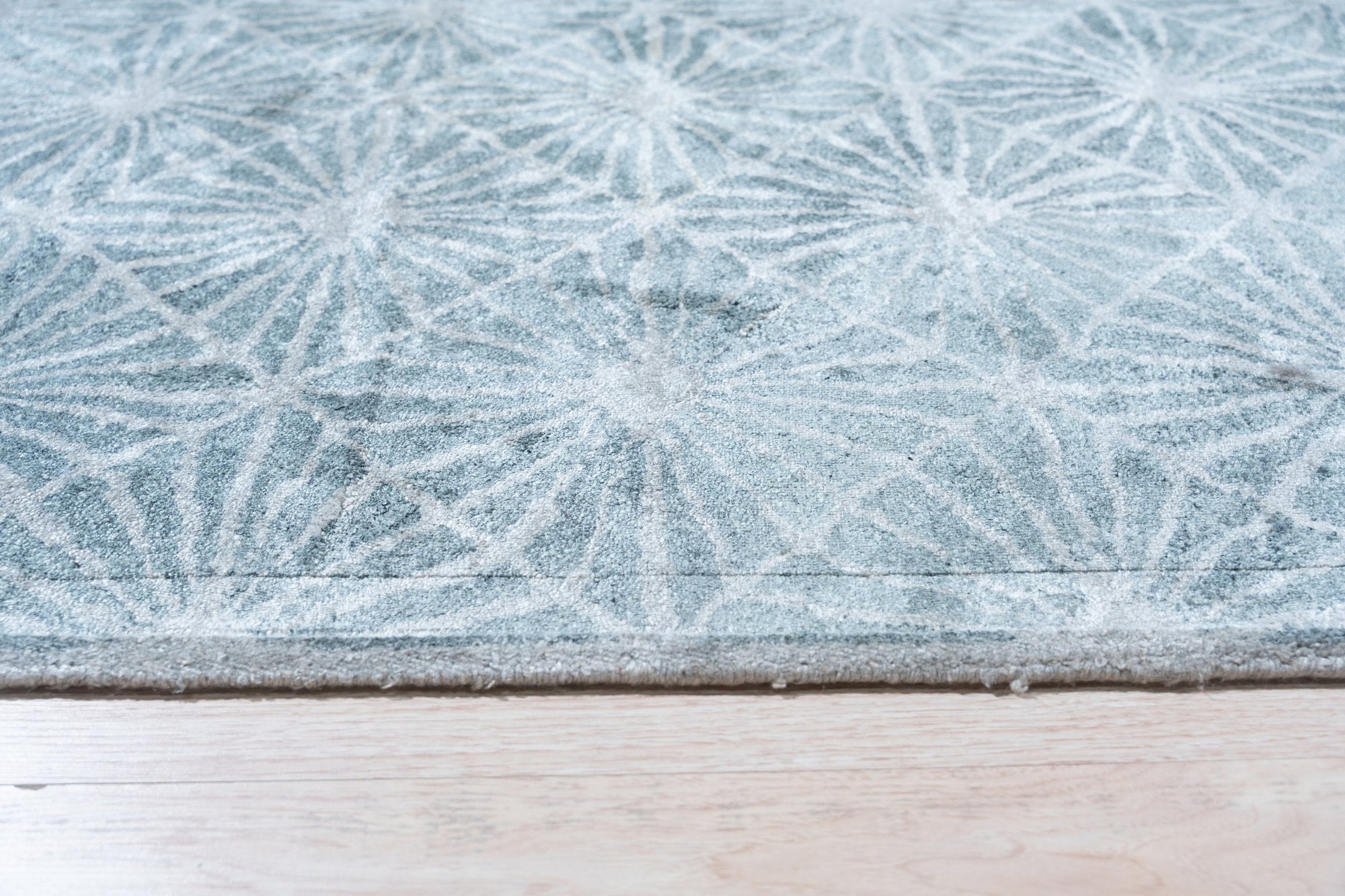 Versatile Yara Ivory Hand Tufted Wool Rug gracing a bright, modern living room. Warm, inviting texture fills the frame, its ivory wool offering a soft, luxurious contrast to the dark hardwood floor. Subtle pattern adds depth without overpowering the minimalist decor.