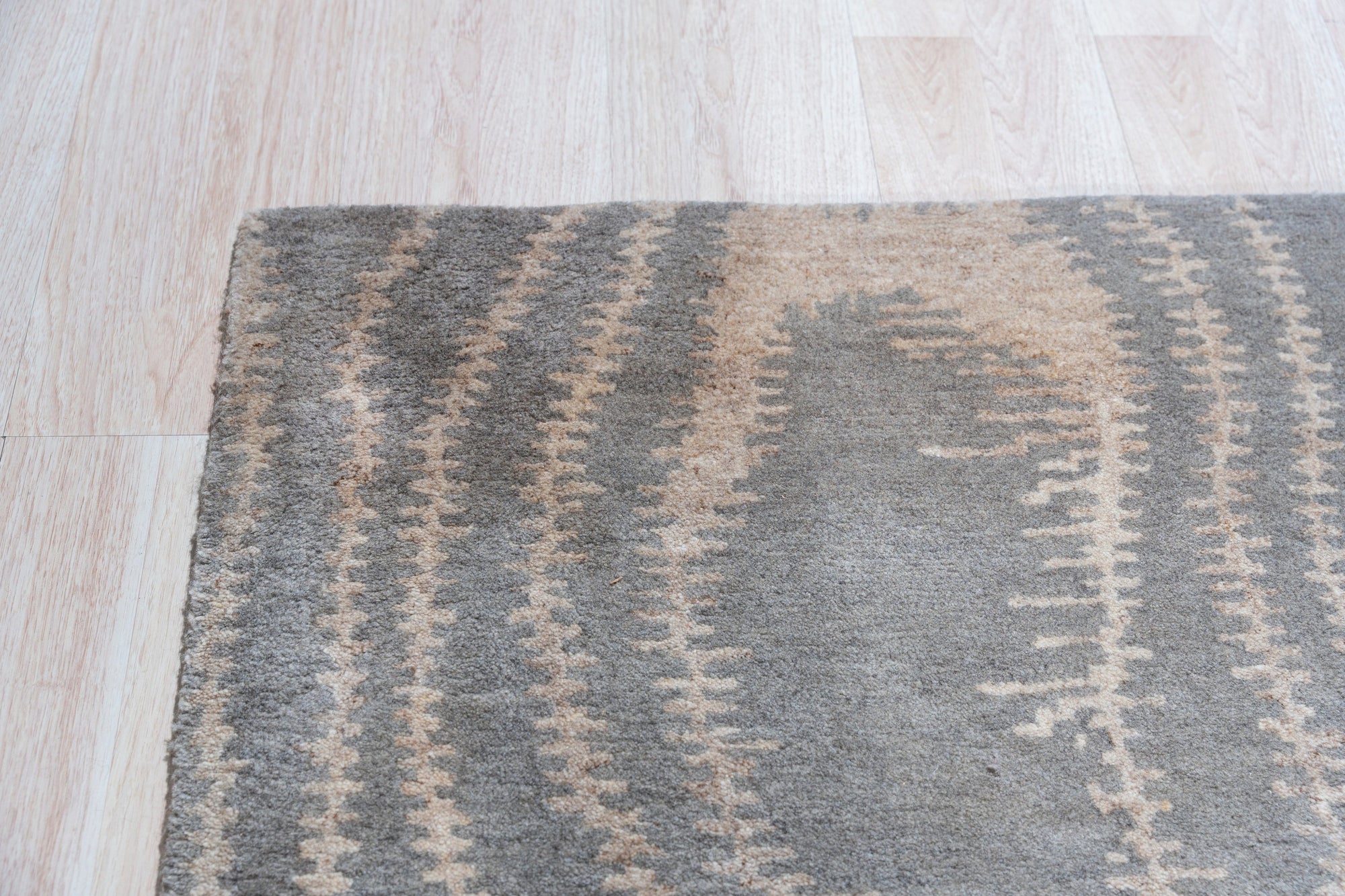 Graceful Captivating Gray Hand Tufted Wool Rug, a gray hand-tufted wool rug with subtle textural variations, displayed in a bright, modern living room setting.