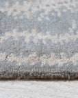 Graceful Captivating Gray Hand Tufted Wool Rug, a gray, hand-tufted wool rug with a subtle, abstract pattern, displayed in a bright, modern living room setting.