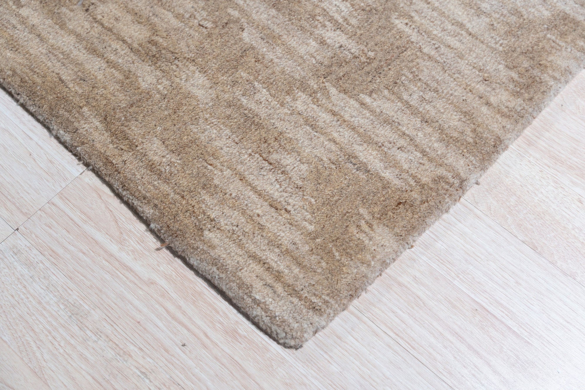 Vibrant Alluring Beige Hand Tufted Wool Rug, displaying its plush texture and subtle beige hues, complements a contemporary living space with light wood flooring and minimalist decor.