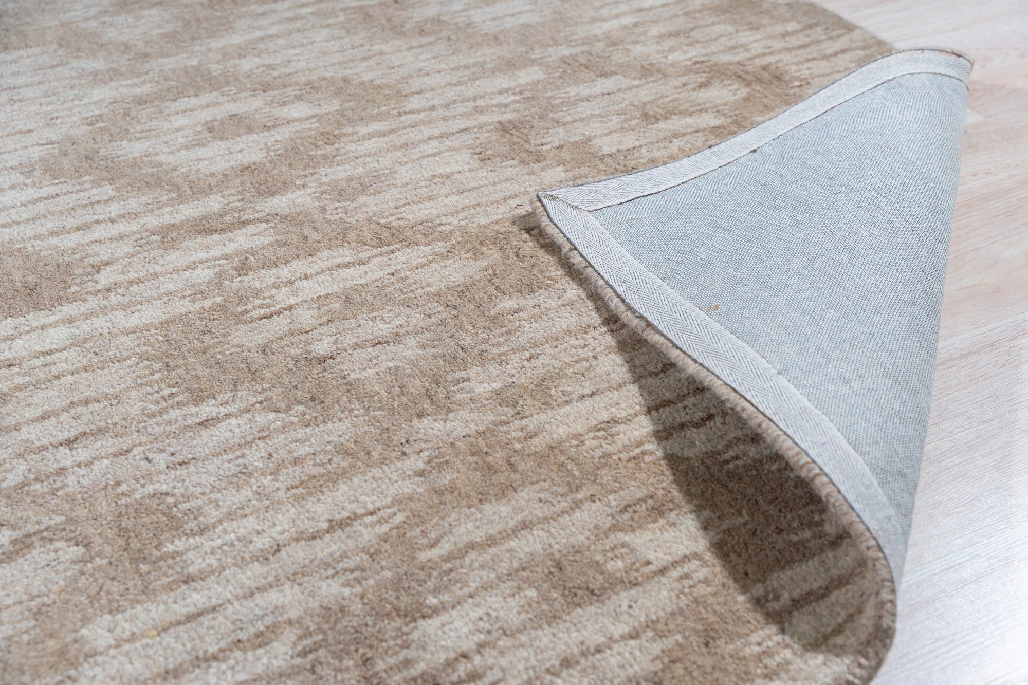 Vibrant Alluring Beige Hand Tufted Wool Rug, a beige wool rug with a textural, potentially geometric design, seen in a bright, modern living space.