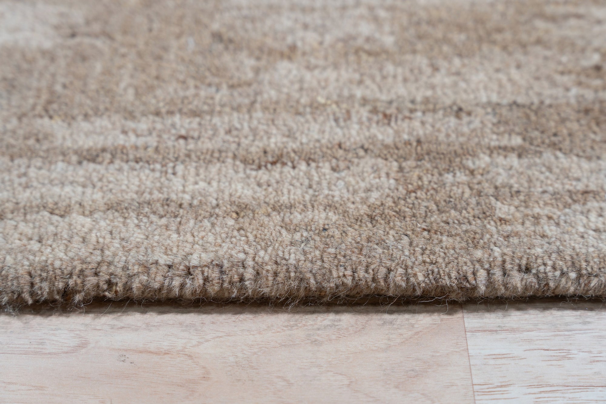 Vibrant Alluring Beige Hand Tufted Wool Rug, soft beige textures meet modern design in a living room setting; its wool pile inviting bare feet and effortless style.