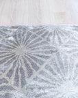 Trendy Timeless Gray Hand Tufted Wool Rug, its subtle variations in gray creating a textured, inviting surface on a polished wood floor in a bright, modern living space.