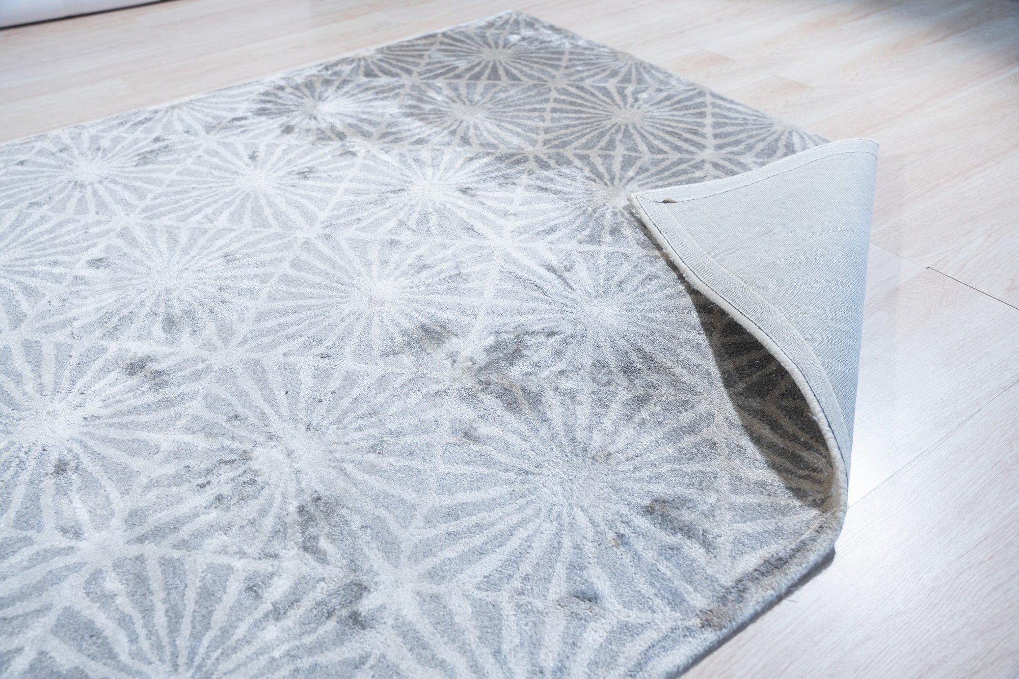 Trendy Timeless Gray Hand Tufted Wool Rug, its subtle texture and neutral gray tones anchoring a modern living room; a coffee table and minimalist decor complete the serene space.