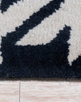 Inviting Timeless Black, White Hand Tufted Wool Rug, showcasing its bold geometric pattern of interlocking diamonds in crisp black and white, adding a modern graphic touch to a living space.