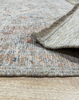 Refined Fiona Blue Handmade Wool Rug, showcasing intricate patterns in shades of blue and ivory, lying gracefully on a light hardwood floor. Subtle texture of the hand-knotted wool visible, accentuating the rug's refined elegance.
