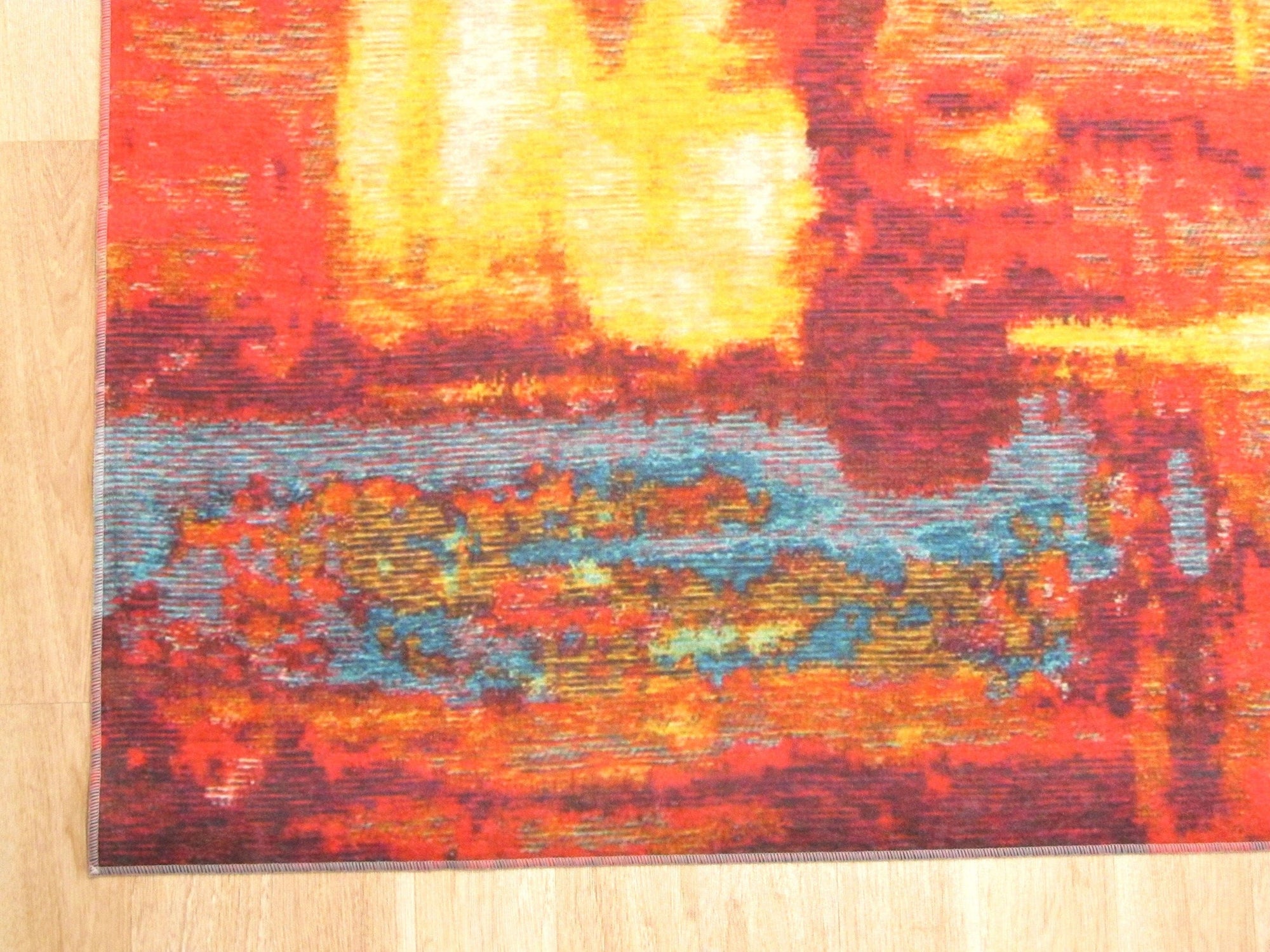 Bianca Isla Red Machine Made Rug displayed in a bright living space, its vibrant red hues and intricate pattern adding warmth and texture to the room.